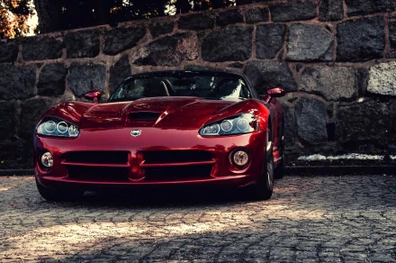 HD PC desktop wallpaper featuring a sleek red Dodge SRT Viper GTS parked on a cobblestone driveway with a stone wall backdrop.
