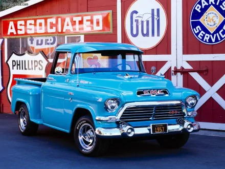 HD PC desktop wallpaper background of a classic turquoise GMC vehicle, a vintage pickup parked in front of retro service and gas station signs.