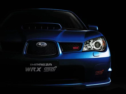 HD PC desktop wallpaper showcasing a close-up of a blue Subaru Impreza WRX STI vehicle front, highlighting its headlight and grille in dramatic lighting.