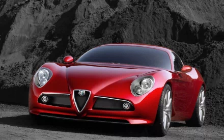 Red Alfa Romeo 8C Competizione sports car set before rugged rock cliffs — HD PC desktop wallpaper and background.