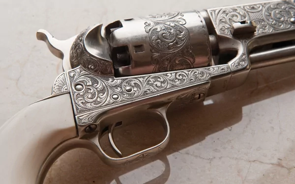 HD PC desktop wallpaper: close-up of a man-made ornate revolver with engraved steel, ivory grip, visible cylinder and trigger resting on a marble background.