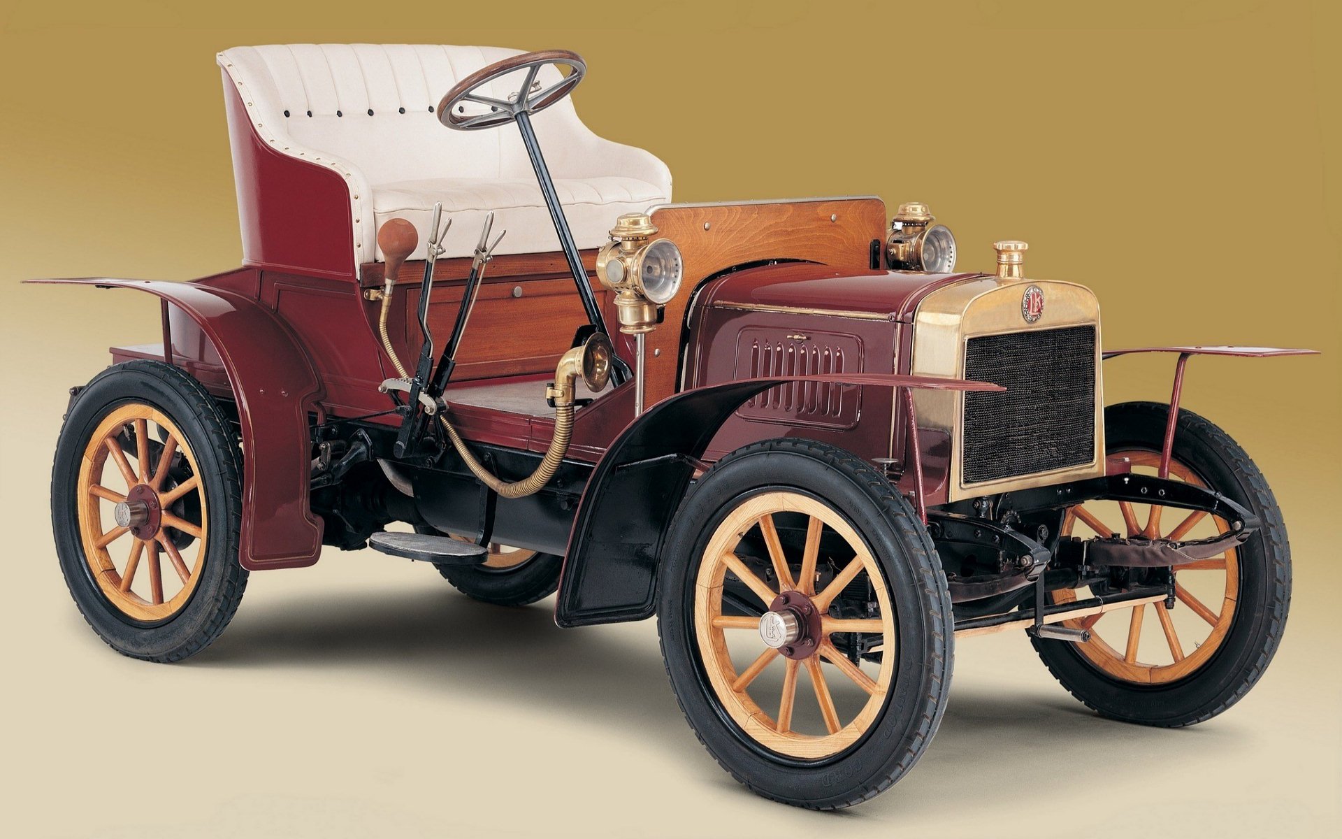 Old vintage classic car: early 1900s open-top vehicle with wooden-spoke wheels on a neutral backdrop — HD PC desktop wallpaper and background.