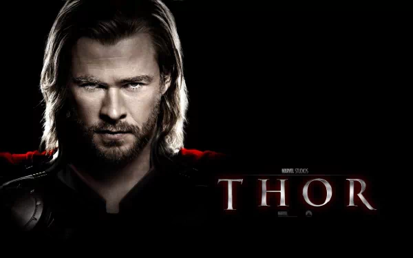High-definition wallpaper featuring Chris Hemsworth as Thor, with a striking close-up and dark background highlighting his intense expression and heroic presence.