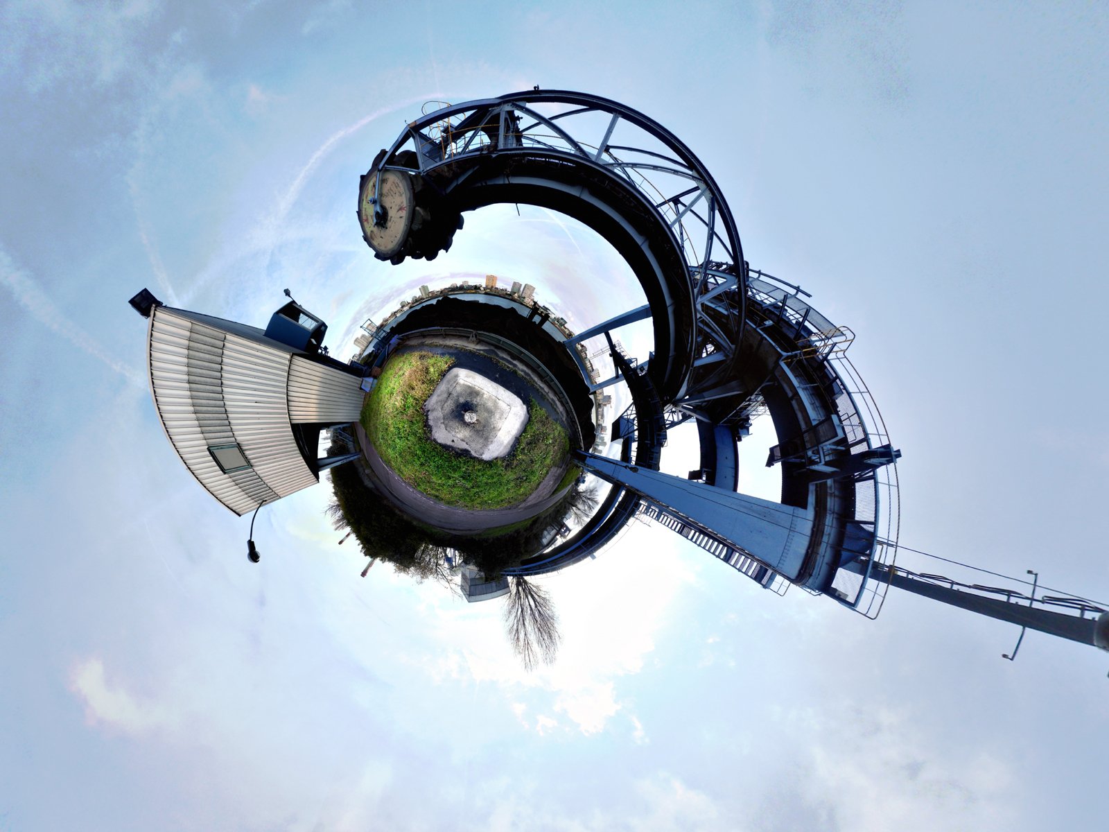Artistic HD cityscape wallpaper featuring a unique circular building and urban structures against a clear sky, creating a striking desktop background.