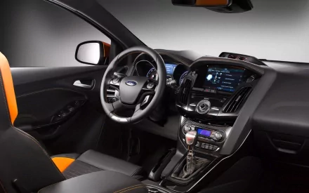 HD PC desktop wallpaper of a Ford Focus interior: steering wheel, dashboard, touchscreen center console and orange-accented seats.