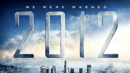 A dramatic HD wallpaper featuring the movie 2012, showcasing the tagline We Were Warned against a backdrop of a turbulent sky and city skyline.