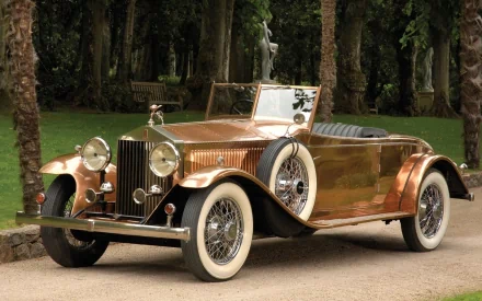 A stunning vintage Rolls-Royce vehicle parked in a lush garden, showcasing its elegant design and classic features, making an exceptional HD desktop wallpaper and background.