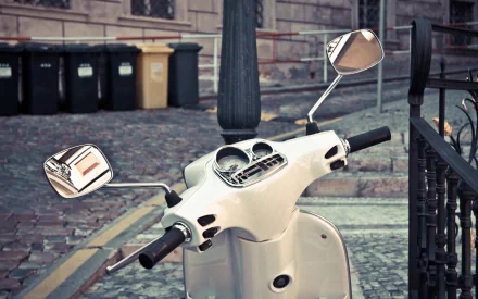 HD desktop wallpaper featuring a white scooter parked on a cobblestone street with a row of trash bins in the background.