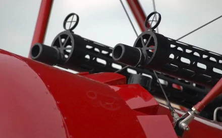 Close-up of mounted weaponry on a military aircraft, showcasing sleek design and intricate details. This HD wallpaper adds a striking element to any desktop background.