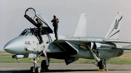 HD desktop wallpaper featuring a military Grumman F-14 Tomcat fighter jet parked on the runway with crew members on and around the aircraft.