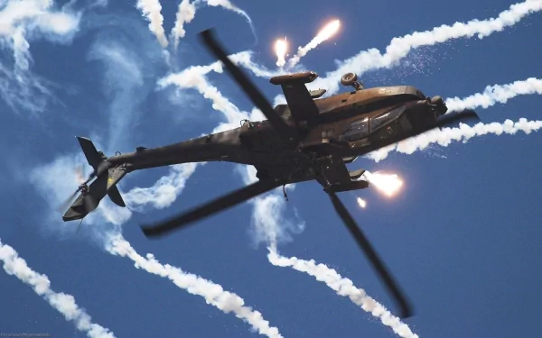 HD desktop wallpaper featuring a Boeing AH-64 Apache military helicopter in flight, releasing countermeasure flares against a clear blue sky.