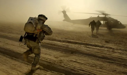 Military personnel run towards a Sikorsky UH-60 Black Hawk helicopter through desert terrain, with dust swirling in the air. The HD image is a dynamic desktop wallpaper and background.