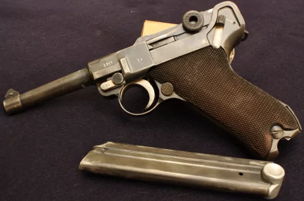 HD desktop wallpaper featuring a detailed close-up of a man-made Luger pistol with its magazine detached, set against a dark background.