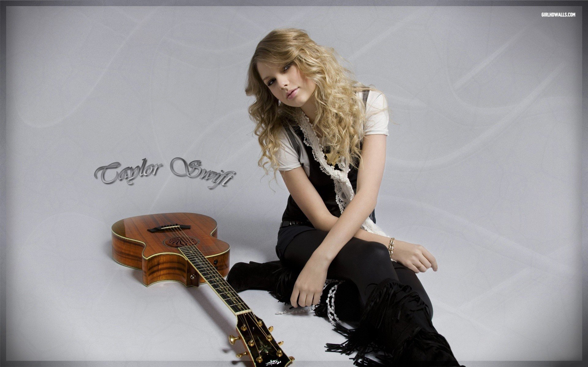 HD PC desktop wallpaper featuring Taylor Swift seated on the floor with an acoustic guitar, showcasing her music-themed portrait and signature.
