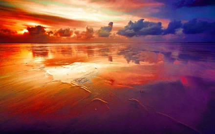 HD desktop wallpaper featuring a stunning sunset over a sandy beach, reflecting vibrant hues of orange, pink, and purple in the water and clouds. Natural, scenic background showcasing the beauty of nature.