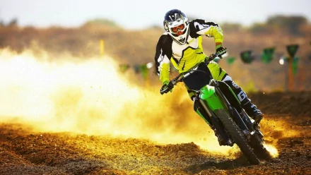 A motocross rider speeds through a dusty track, kicking up dirt as they showcase their skills in this dynamic HD wallpaper, capturing the thrill of sports.