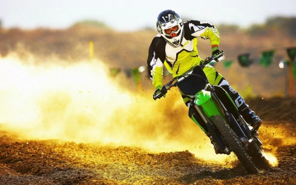 A motocross rider speeds through a dusty track, kicking up dirt as they showcase their skills in this dynamic HD wallpaper, capturing the thrill of sports.
