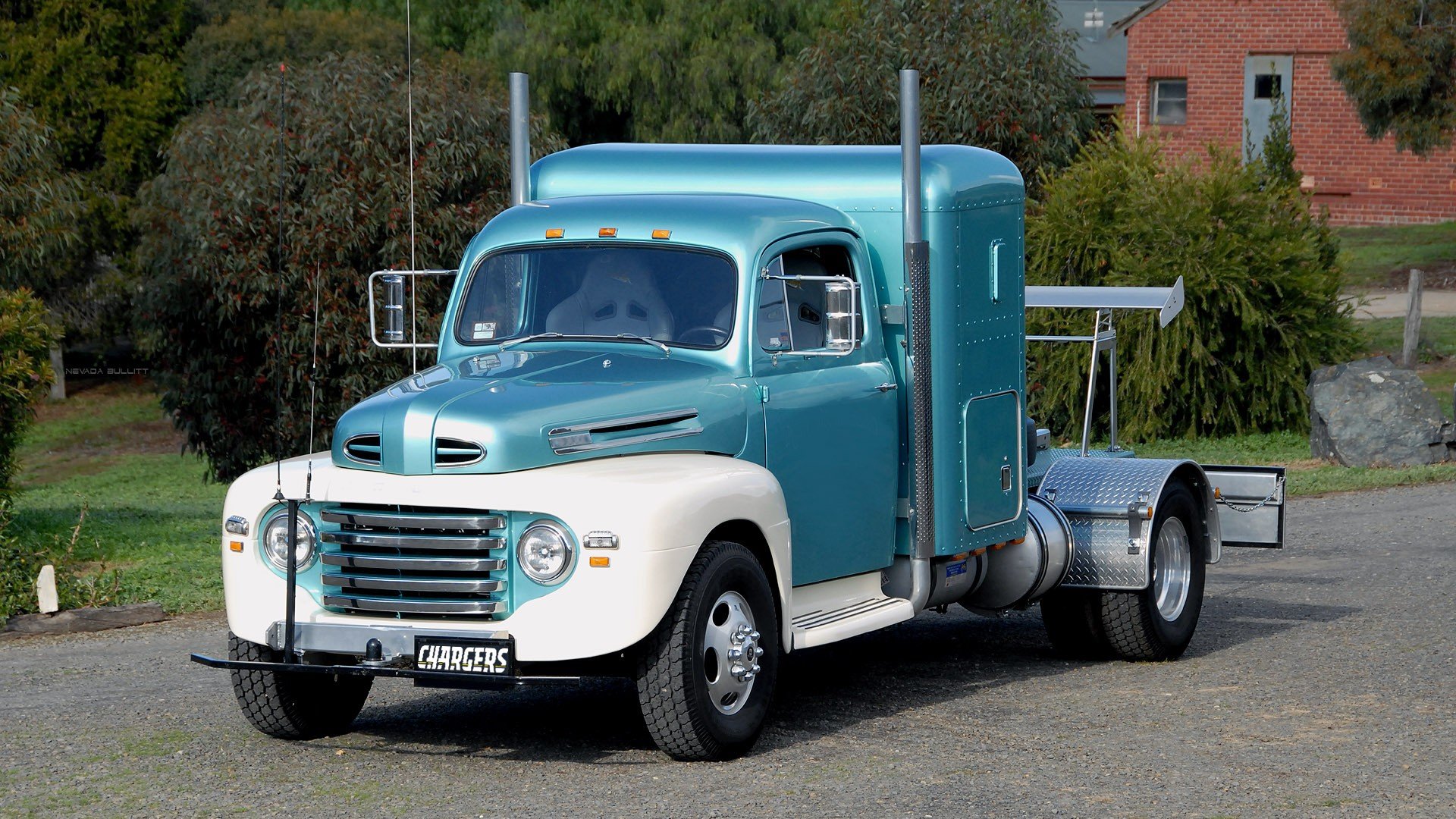 A vintage blue and white truck parked on a gravel surface, showcasing its classic design. This high-definition image serves as a striking PC desktop wallpaper and background.