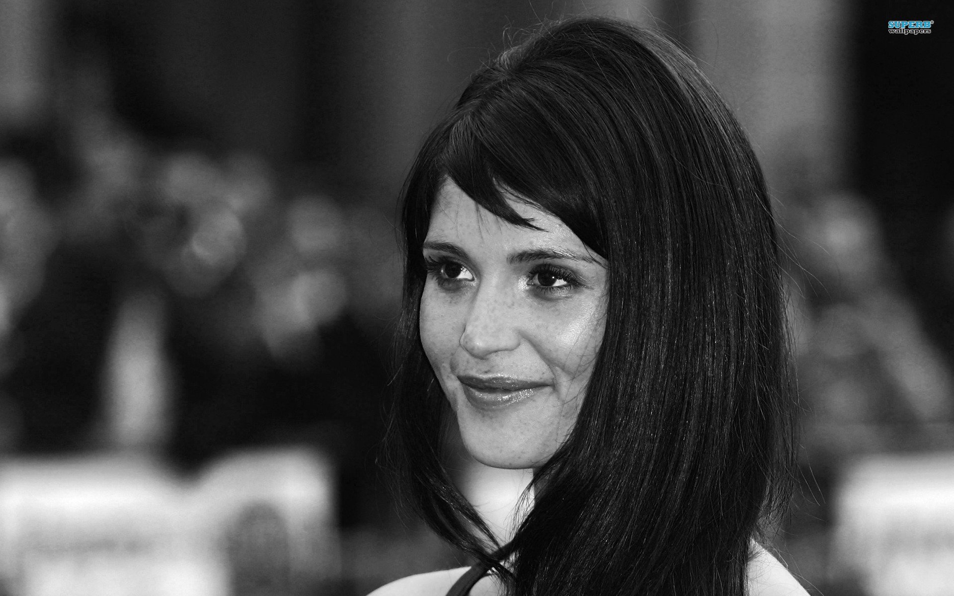 Black and white HD desktop wallpaper featuring a close-up portrait of celebrity Gemma Arterton with a subtle smile and long dark hair.
