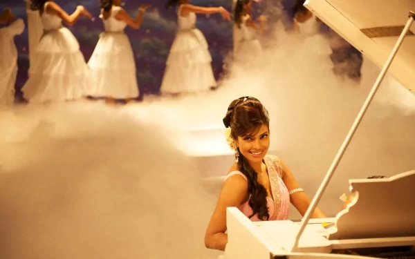 A vibrant HD desktop wallpaper featuring Priyanka Chopra sitting at a piano, surrounded by a misty atmosphere and dancers in white dresses, exuding elegance and charm.