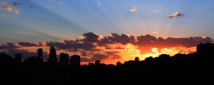 HD desktop wallpaper showcasing a vibrant sunset over the man-made skyline of Minneapolis with dramatic clouds and radiant sky colors.