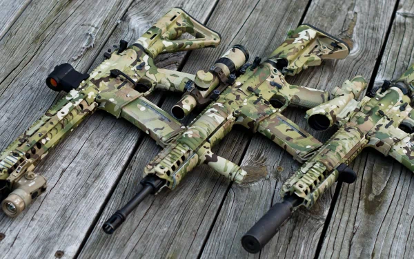 Man-made camouflaged assault rifles laid on weathered wooden planks — 2K Quad HD PC desktop wallpaper/background.