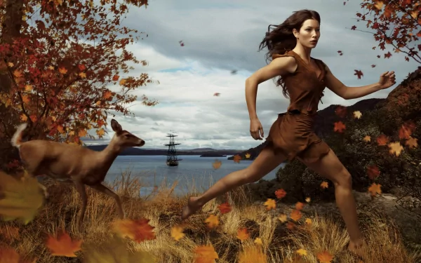 Jessica Biel runs through a vibrant autumn landscape alongside a deer, with a ship visible in the background. This enchanting image is part of the Disney Dream Portraits collection.