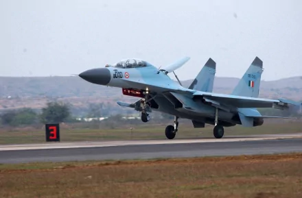 A high-definition desktop wallpaper featuring a Sukhoi Su-30MKI military aircraft taking off, painted in blue and grey, with hills in the background.