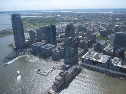 Aerial HD desktop wallpaper of Jersey City's man-made waterfront skyline with tall buildings and the surrounding cityscape.