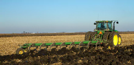 A John Deere vehicle plowing a field, showcasing the power and efficiency of agricultural machinery. This HD image serves as a striking desktop wallpaper and background.