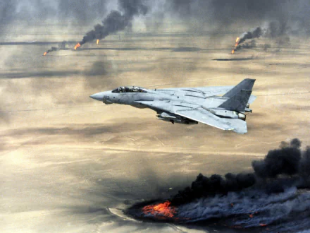 HD PC desktop wallpaper showing a military aircraft flying over burning oil fields during the Gulf War, with thick black smoke rising against a desert backdrop.