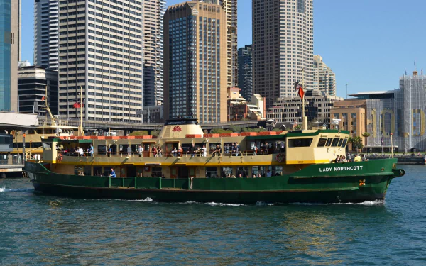 The image showcases the Lady Northcott ferry at Circular Quay in Sydney, Australia, framed by city skyscrapers and a vibrant harbor scene.