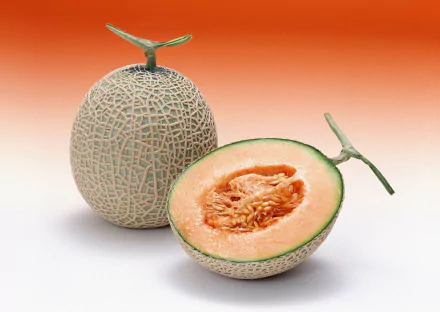 HD desktop wallpaper featuring a whole cantaloupe melon and a halved cantaloupe, showcasing the textured rind and juicy orange flesh inside.
