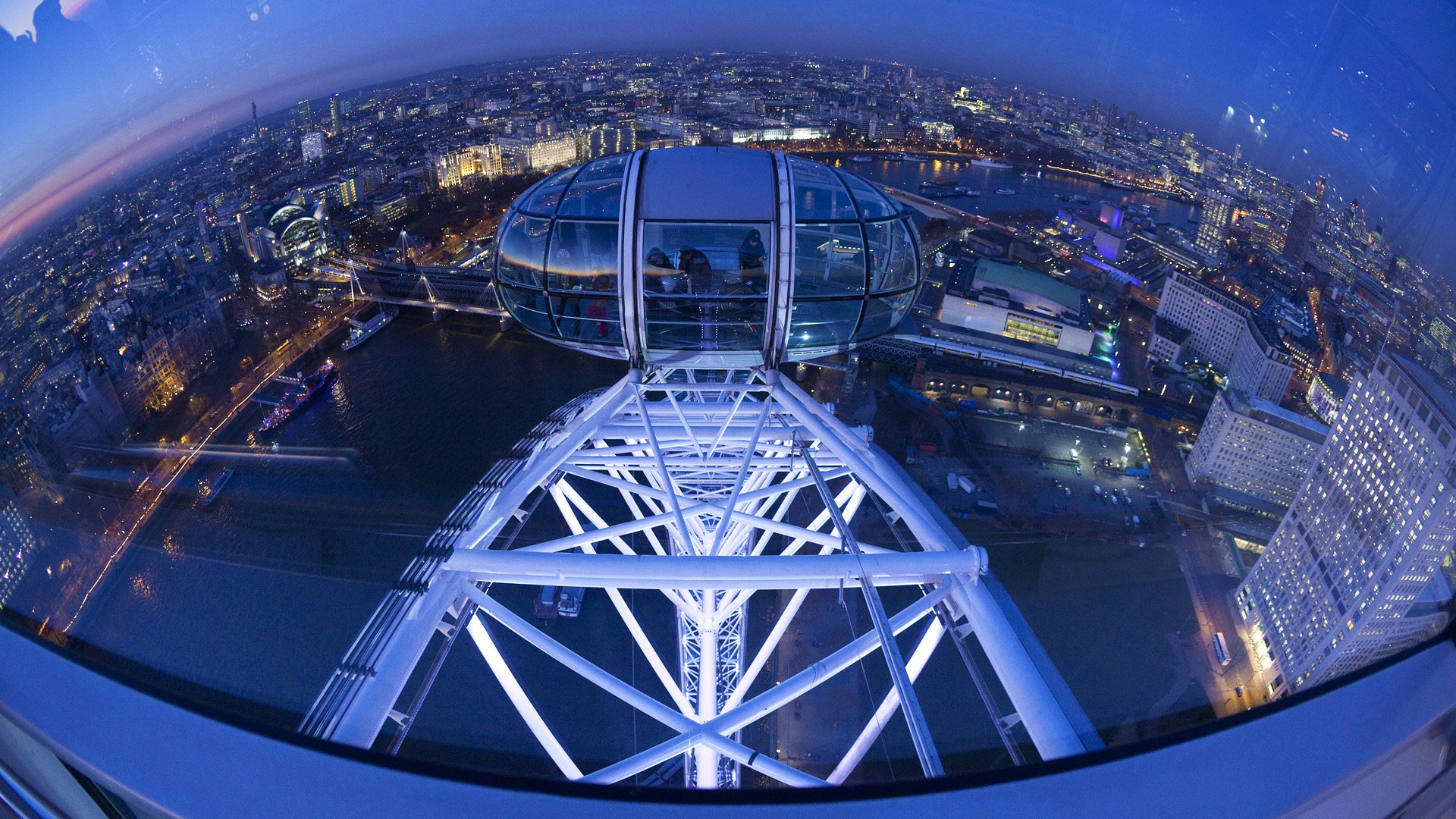 Fisheye view from the London Eye capsule overlooking illuminated cityscape at night, captured in HD for a striking desktop wallpaper background.