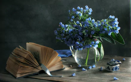 HD still life photography features an open book and a glass vase with small blue flowers arranged on a wooden surface, captured as a PC desktop wallpaper background.