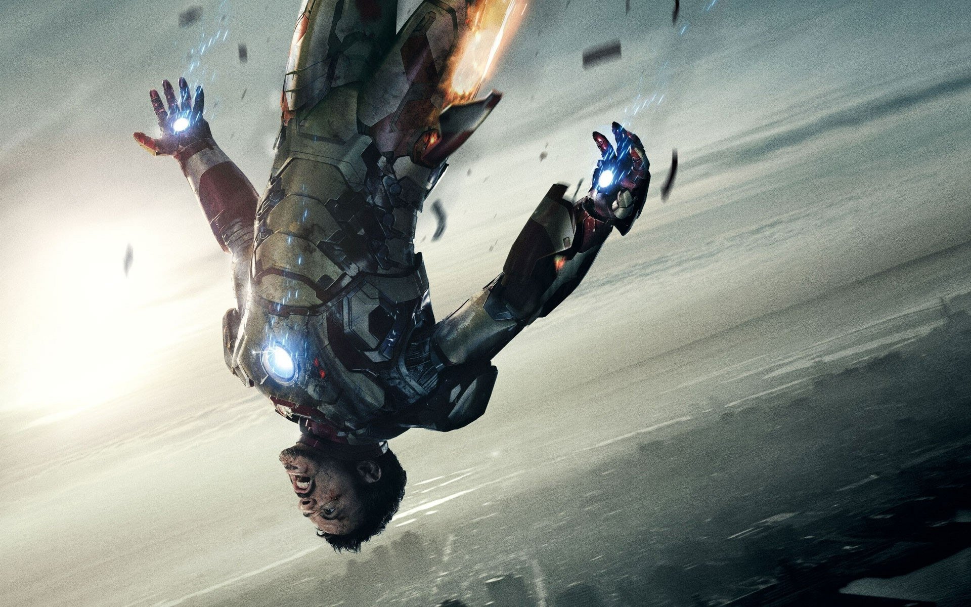 HD PC desktop wallpaper from the movie Iron Man 3: Iron Man tumbling through a stormy sky, repulsors and arc reactor glowing.