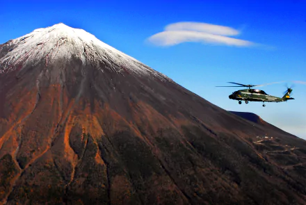 A Sikorsky SH-60 Seahawk military helicopter flies near Mount Fuji in Japan under a clear blue sky in this 4K Ultra HD desktop wallpaper.