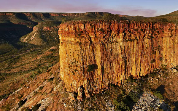HD desktop wallpaper of rugged red rock cliffs and expansive natural landscape in the Kimberley region, showcasing its dramatic terrain and vibrant colors.