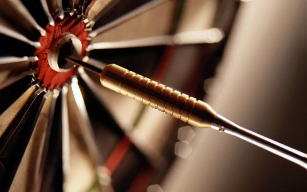 Close-up of a dart embedded in a dartboard, showcasing the intricate details of the dart's tip and the board's segments, creating a dynamic HD desktop background.