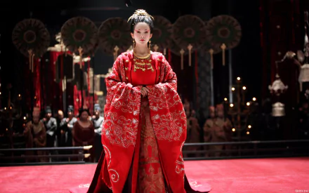 HD PC desktop wallpaper featuring celebrity Zhang Ziyi in an elaborate red traditional costume, standing confidently in a dramatic, ceremonial setting.