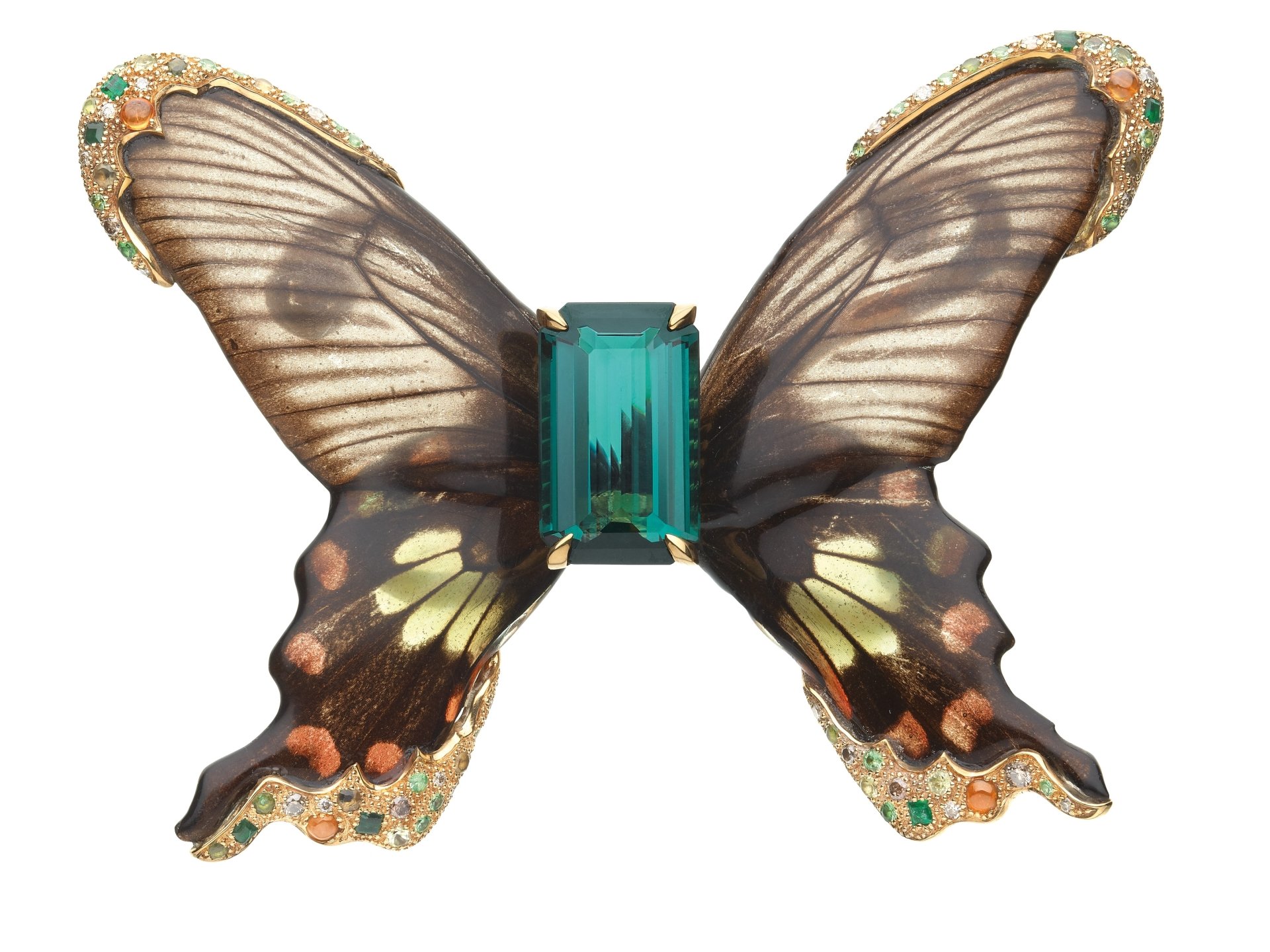 Man-made jewelry: butterfly-shaped brooch with translucent patterned wings and central emerald-cut gemstone, presented as a 2K Quad HD PC desktop wallpaper/background.