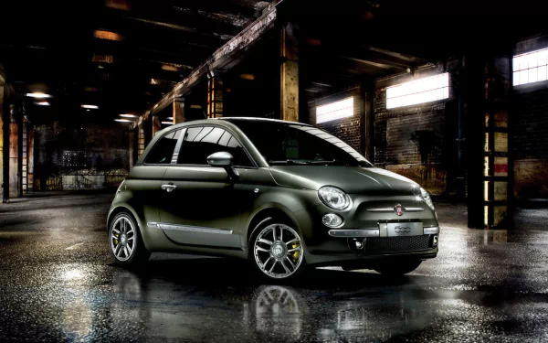 HD PC desktop wallpaper featuring a sleek Fiat vehicle parked in an industrial, dimly lit setting with reflective wet flooring.