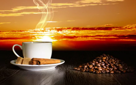 A steaming cup of coffee sits beside cinnamon sticks and sugar cubes on a wooden surface, with a backdrop of a vibrant sunset and scattered coffee beans, making a captivating HD desktop wallpaper.