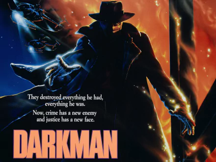 Darkman movie 2K Quad HD PC desktop wallpaper and background: masked trenchcoat figure with hat emerges from flames and smoke, dramatic lighting, film title and tagline at lower left.