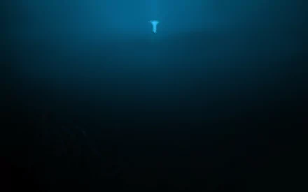 A serene underwater scene features a glowing jellyfish illuminated against a deep blue ocean backdrop, creating a captivating fantasy atmosphere for a HD desktop wallpaper.