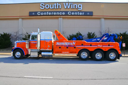 4K Ultra HD desktop wallpaper of an orange and blue Peterbilt tow truck parked outside a conference center labeled South Wing.