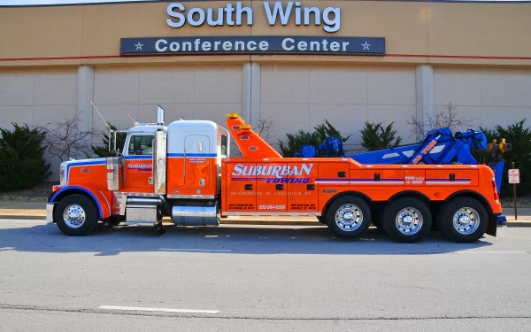 4K Ultra HD desktop wallpaper of an orange and blue Peterbilt tow truck parked outside a conference center labeled South Wing.