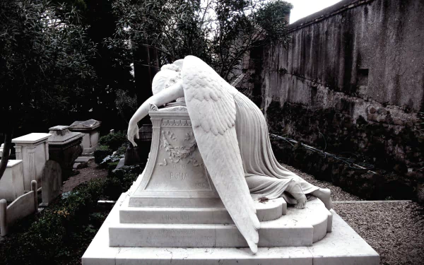A serene angel statue rests its head on a pedestal, capturing a moment of quiet reflection. This striking HD PC desktop wallpaper adds a touch of elegance to any background.