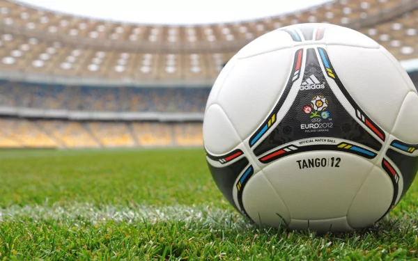 HD desktop wallpaper featuring an Adidas Tango 12 soccer ball on the grass inside a stadium, representing UEFA Euro 2012 and the spirit of sports.