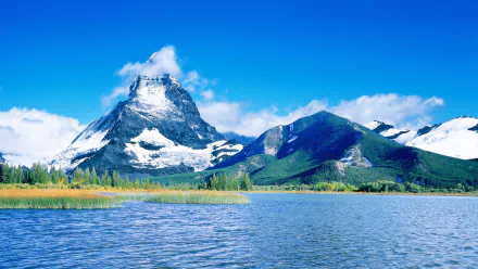 A stunning HD wallpaper featuring the iconic Matterhorn mountain, surrounded by lush greenery and a serene lake under a clear blue sky, showcasing the beauty of nature.